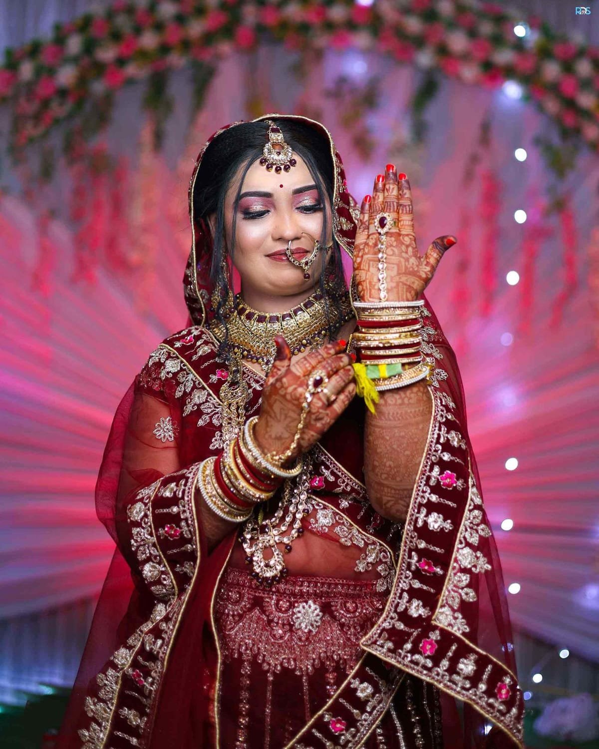 Bridal portrait in a red lehenga with gold jewellery