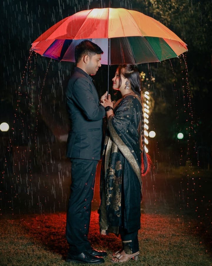 Couple under an umbrella during a rain-themed shoot