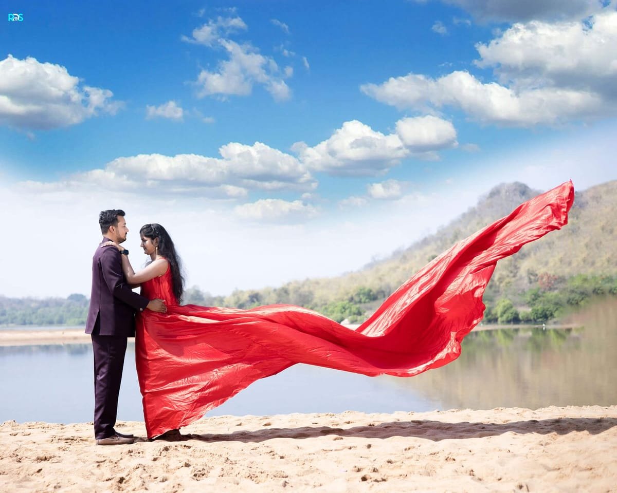 Pre-wedding shoot by the river with a flowing red dupatta